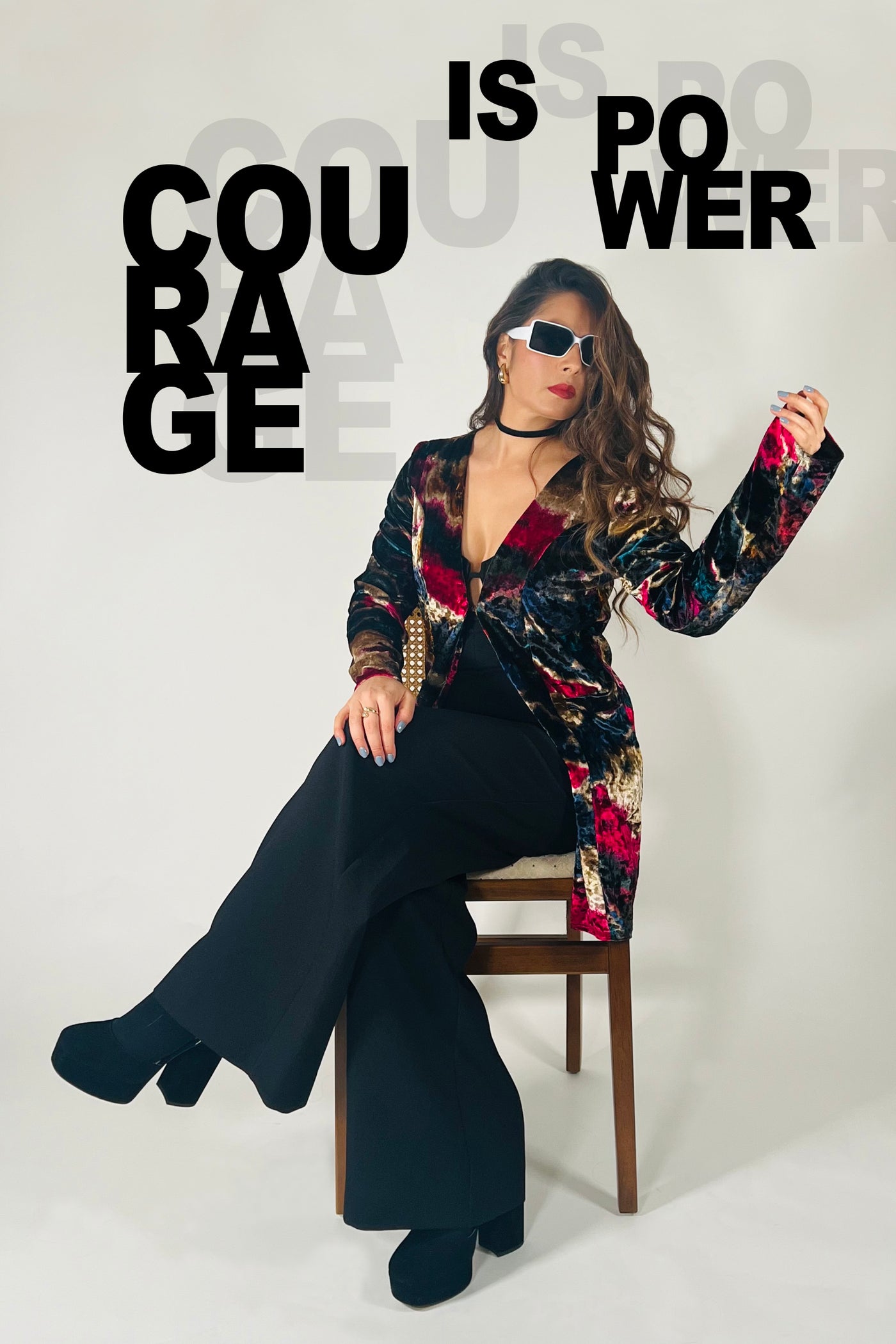 Woman sitting on a chair with text 'Courage is power' displayed.