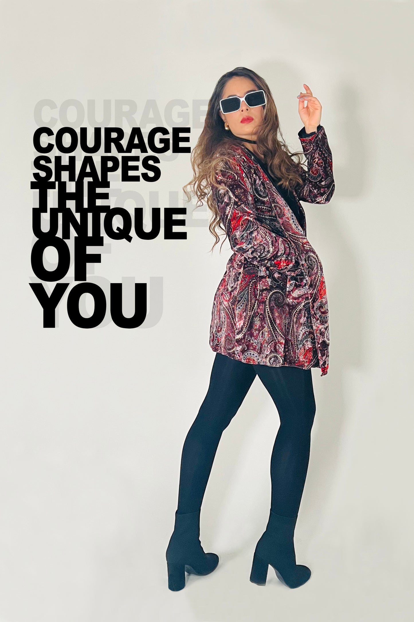 Woman in a patterned dress with sunglasses, standing against a white background with motivational text.