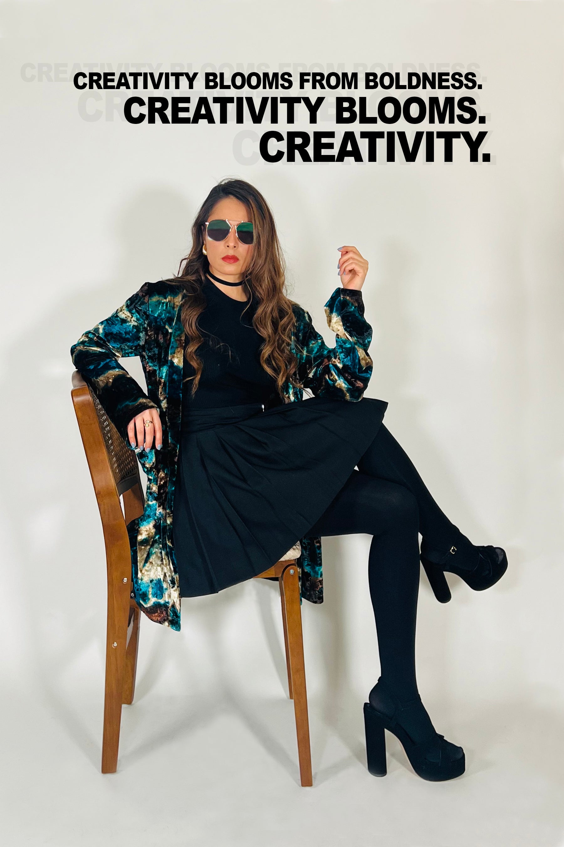 Woman sitting on a chair wearing a floral coat and black outfit with text about creativity.