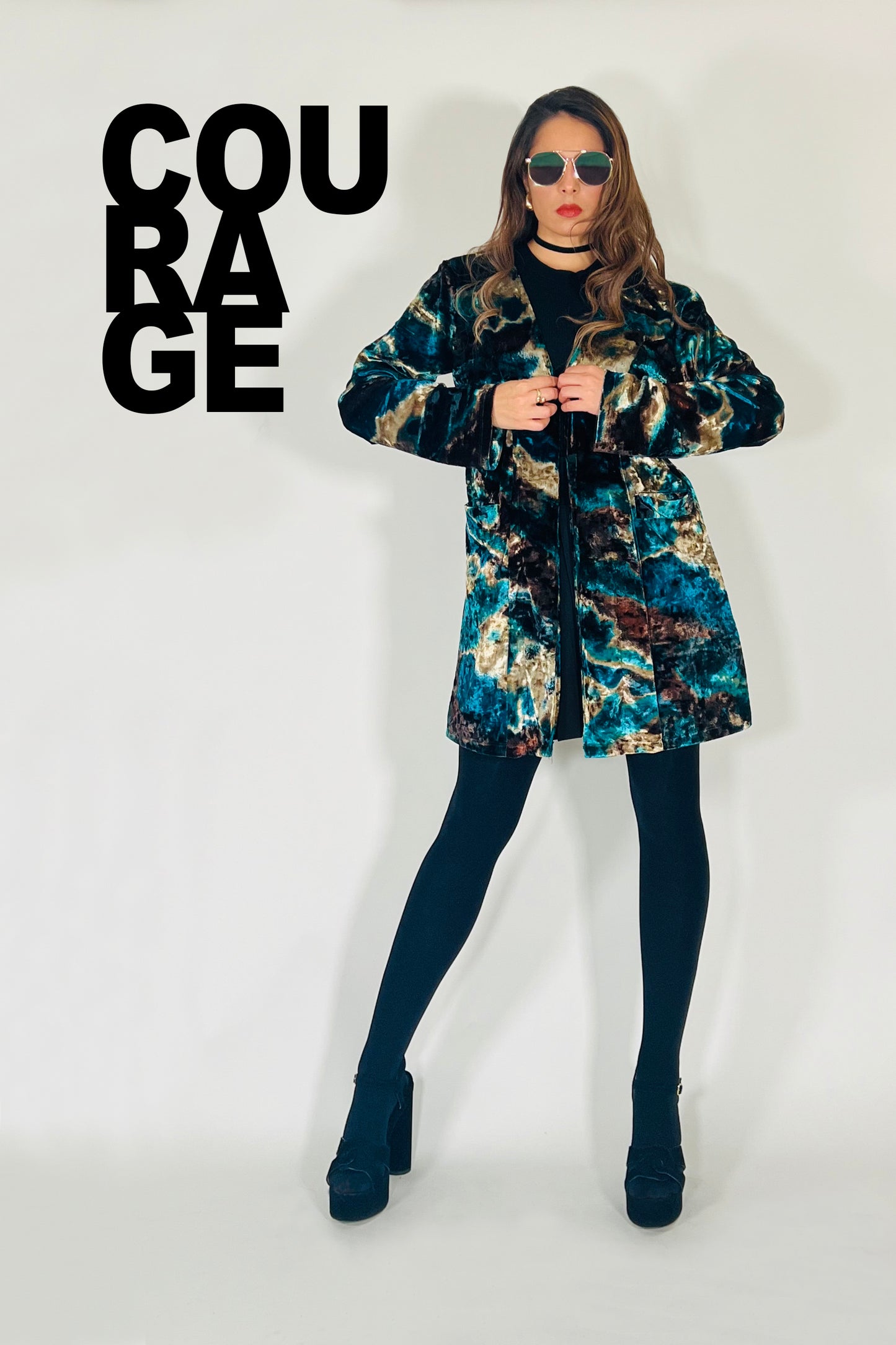 Woman wearing a patterned coat with the word 'COURAGE' displayed.